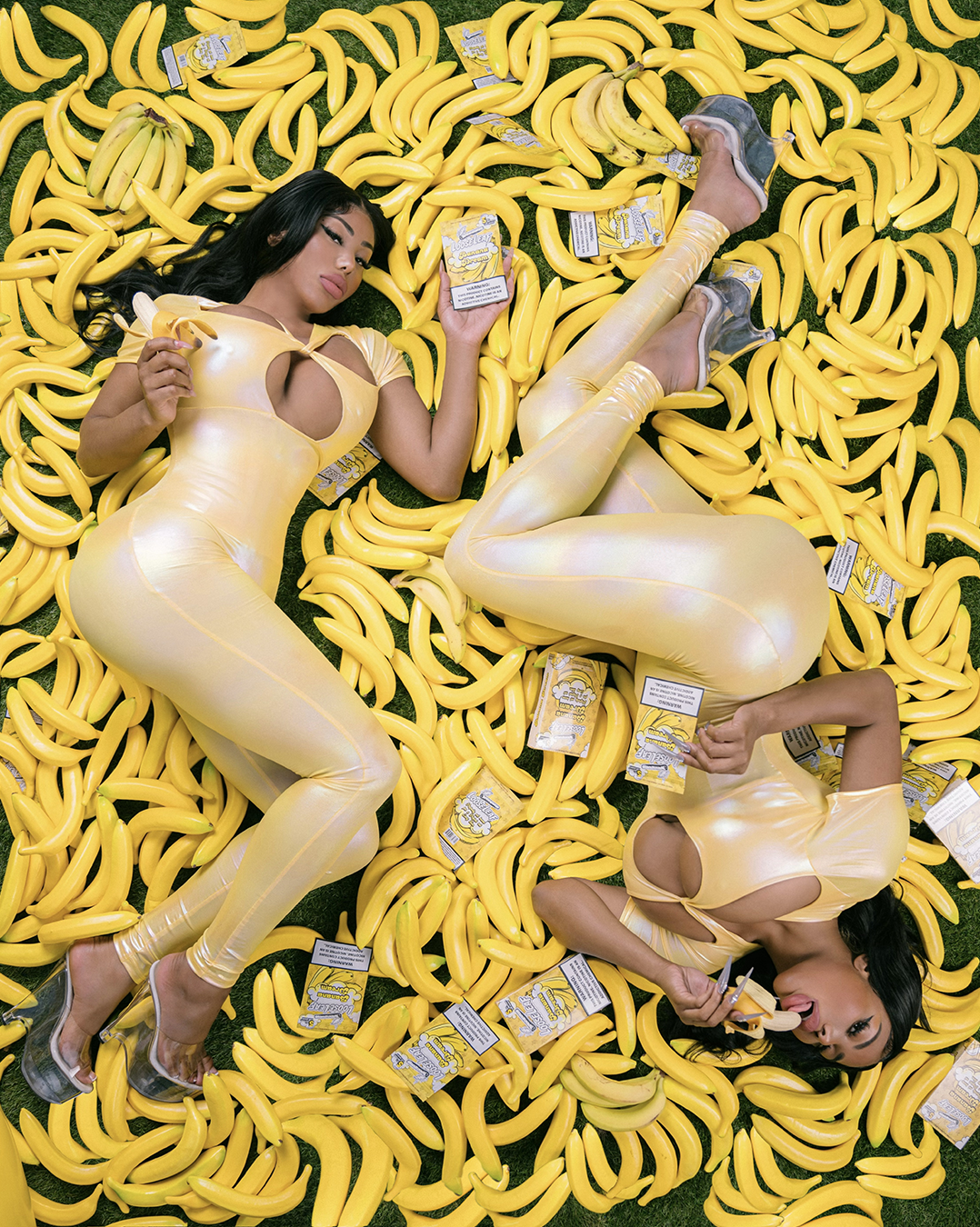 The Clermont Twins in yellow outfits sitting on a banana-shaped couch with 'Loose Leaf' BANANA DREAM 