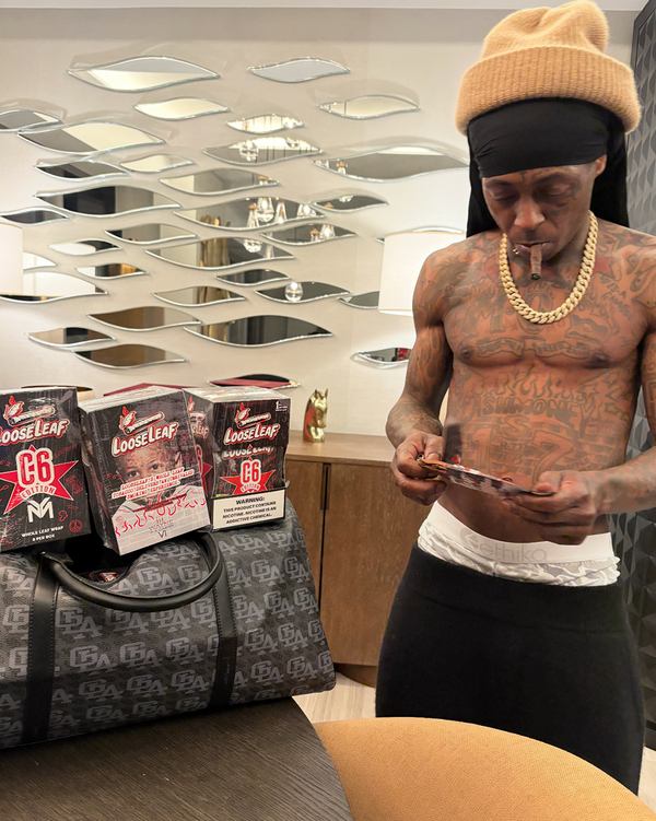 LIL WAYNE  holding a C6 EDITION loose leaf.