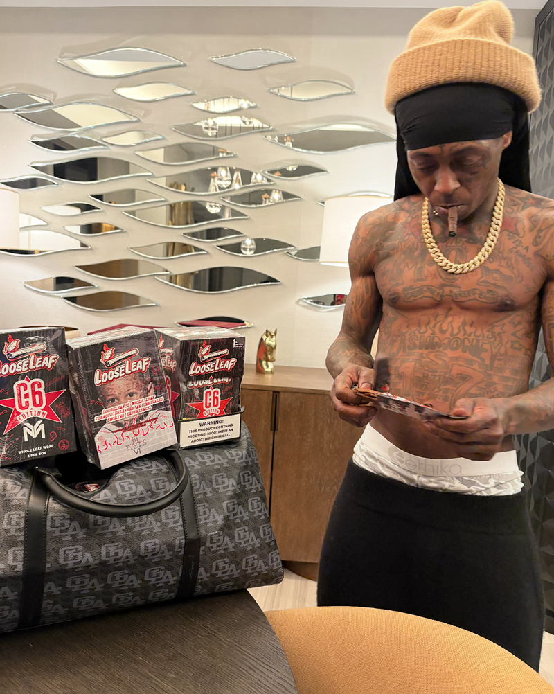 LIL WAYNE  holding a C6 EDITION loose leaf.